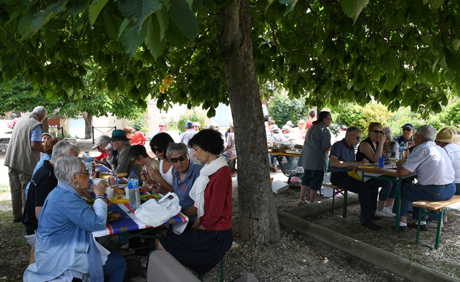 Les participants attablés sous les arbres