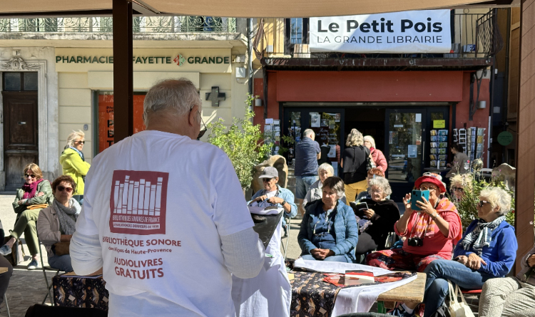 Lecture devant la librairie Le Petit Pois par l'un de nos Donneurs de Voix