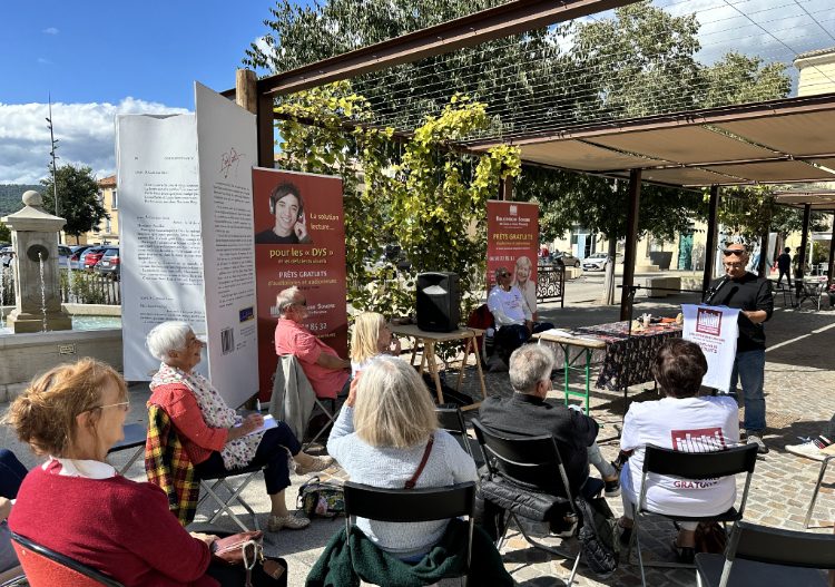 Le public assistant aux lectures sous l'ombrière de la place du Terreau à Manosque'